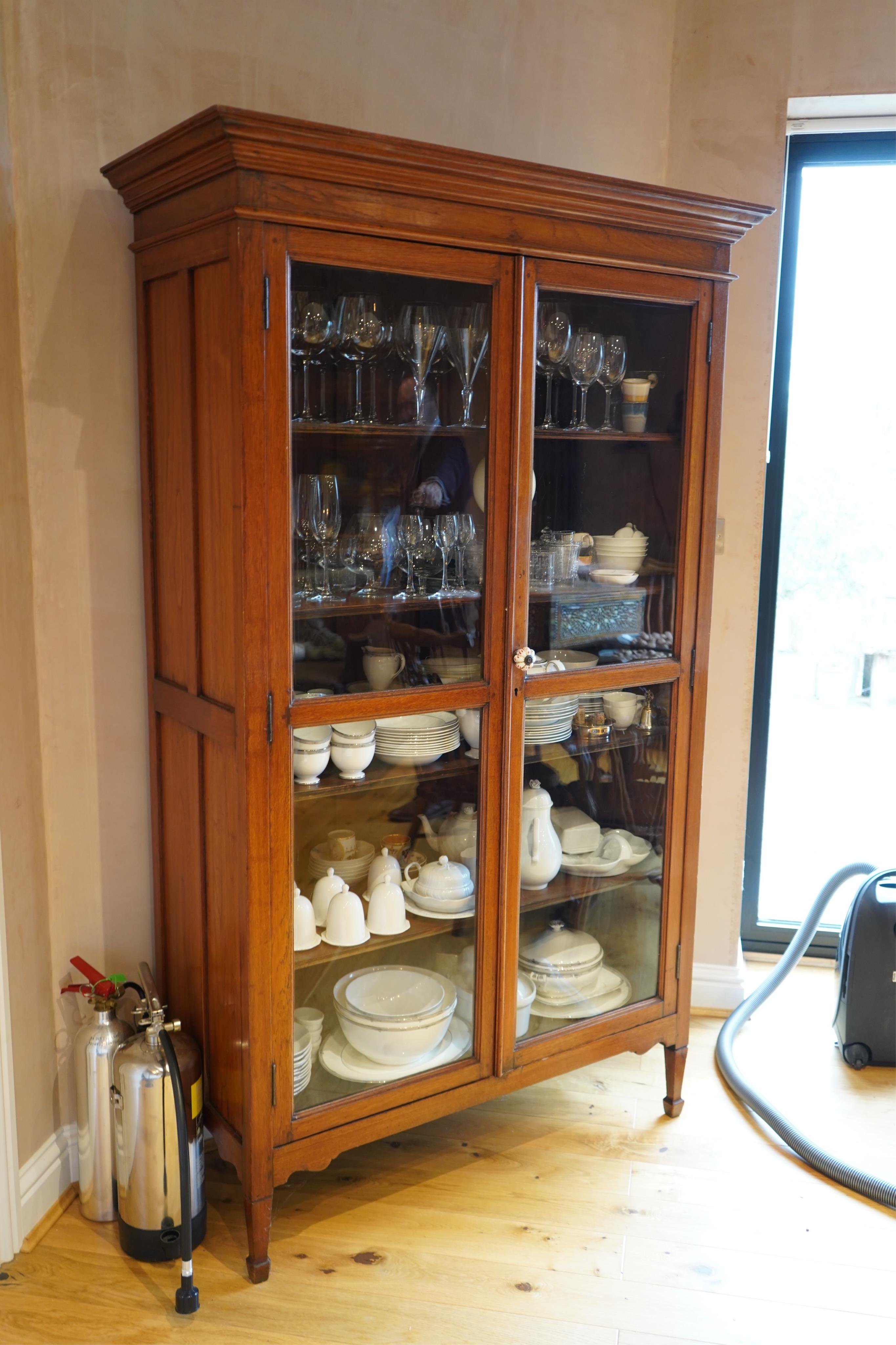 A late 19th century Indian teak glazed cabinet, width 120cm, depth 48cm, height 198cm. Condition - good